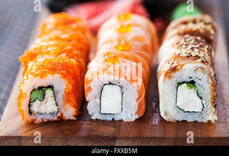 Un assortimento di prodotti freschi fatti in casa rotoli di sushi sul tavolo Foto Stock