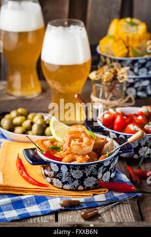 Selezione di tapas spagnole antipasti - Gamberetti, pepe, olive, grano e bicchieri di birra Foto Stock