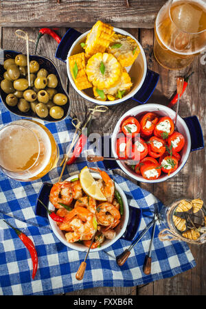 Selezione di tapas spagnole antipasti - Gamberetti, pepe, olive, grano e bicchieri di birra Foto Stock