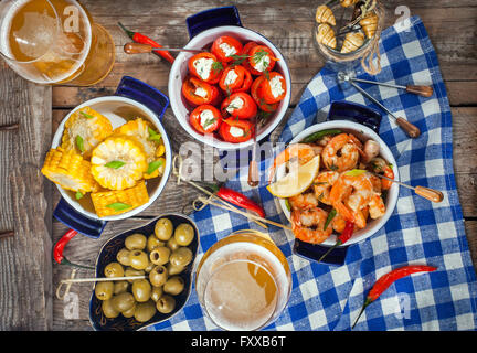 Selezione di tapas spagnole antipasti - Gamberetti, pepe, olive, grano e bicchieri di birra Foto Stock