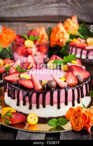 Delizioso a due veli Strawberry Cheesecake (torta decorata con cioccolato e frutti di bosco freschi Foto Stock