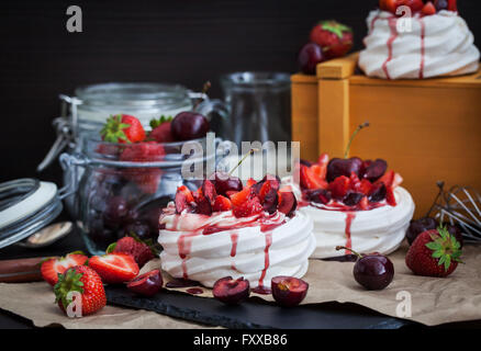 Porzione di mini Pavlova meringa torta decorata con un fresco e fragola e ciliegia Foto Stock