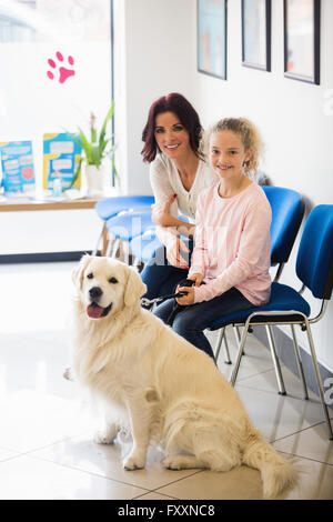 Felice madre e figlia seduti con il cane Foto Stock