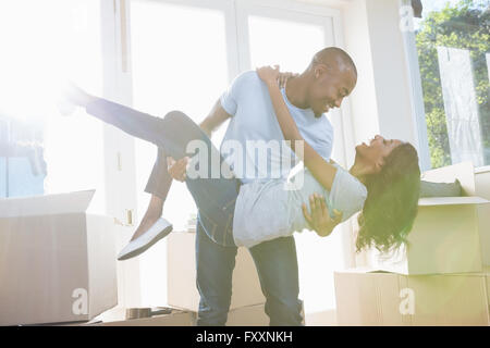 Giovane donna di sollevamento nelle sue braccia Foto Stock