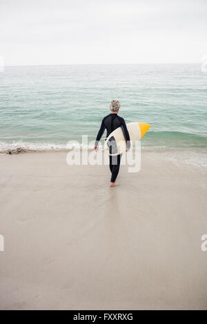 Vista posteriore del senior Donna che cammina verso il mare Foto Stock