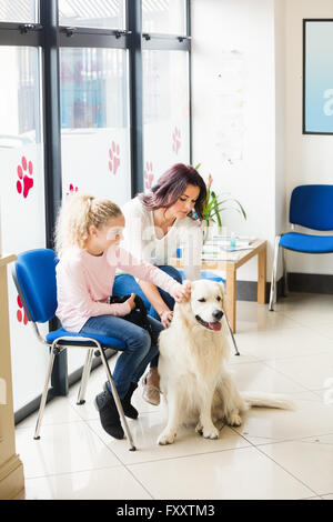 Madre e figlia seduti con il cane Foto Stock