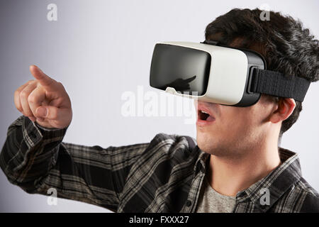 Giovane uomo che indossa la realtà virtuale auricolare Foto Stock