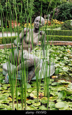 Paesaggio con donna scultura in lily pond Foto Stock