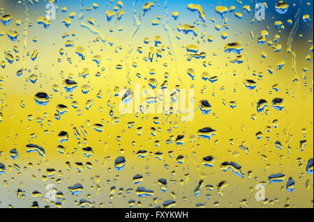 La pioggia le goccioline di acqua sul bagnato autovettura finestra in vetro Foto Stock