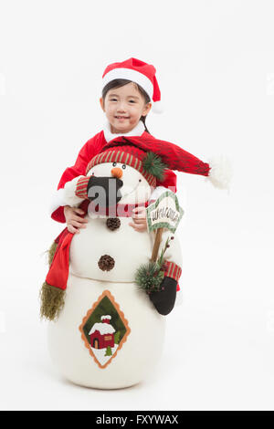 Ragazza sorridente in santa vestiti di pupazzo di neve abbracciando con lo sguardo sul lato anteriore Foto Stock