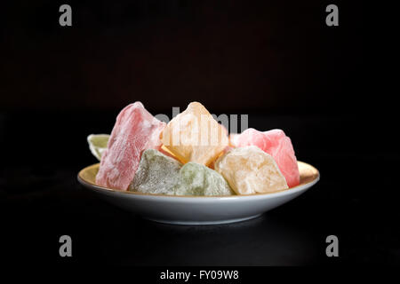 Turkish Delight pezzi sulla piastra scuro su sfondo nero Foto Stock