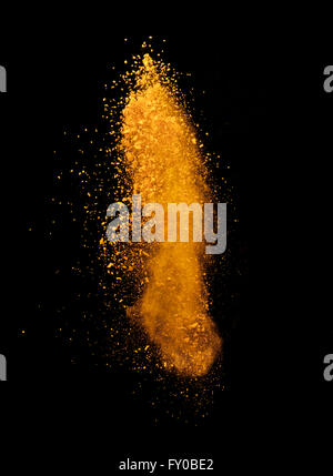 Esplosione di polvere di colore giallo su sfondo nero Foto Stock