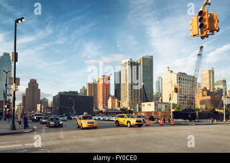 La città di NEW YORK, giugno 17,2015: auto e taxi attraversando l'intersezione di 34th St e undicesimo Ave, lungo il cantiere per la costruzione di 3 H Foto Stock