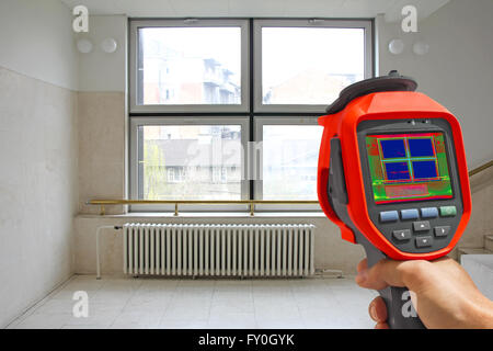 La registrazione il radiatore del riscaldatore e una finestra su un edificio utilizzando termocamera infrarossa Foto Stock