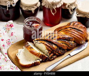 Frutta e marmellata di frutti di bosco in vasi. Diversi tipi di panini. Messa a fuoco selettiva. Foto Stock
