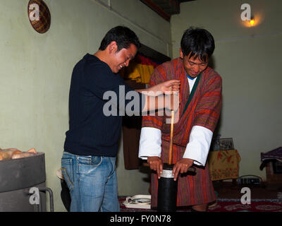 Due uomini rendendo il burro salato tè con un tasso di abbandono della tradizionale in Kurjey, Bumthang, Bhutan. Foto Stock