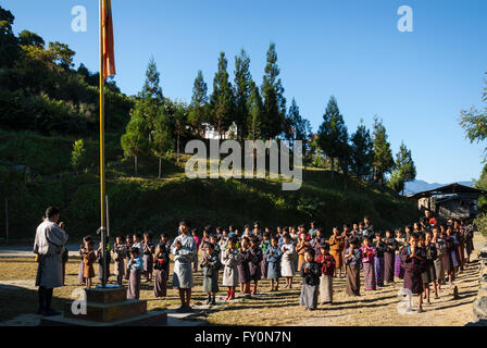 Gli studenti che indossano vestiti tradizionali al gruppo di mattina in una scuola elementare nel villaggio Nimshong nel sud del Bhutan Foto Stock