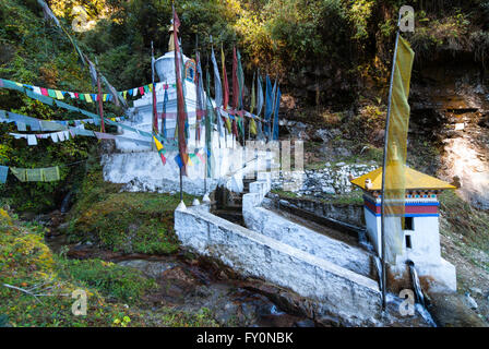 Acqua-girare la ruota di preghiera e stupa accanto alla strada tra Dochu La e Metshina in western Bhutan Foto Stock