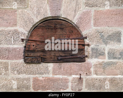 Round piccola porta di legno in una vecchia muratura Foto Stock