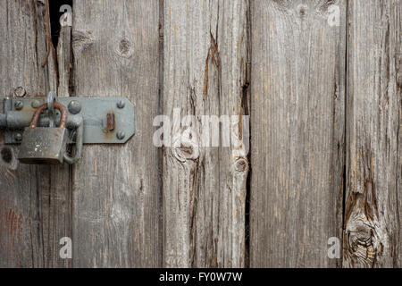 Serratura e lucchetto arrugginito sul legno stagionato porta da pannello Foto Stock
