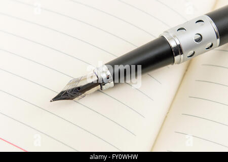 Nero penna stilografica su un notebook aperto Foto Stock