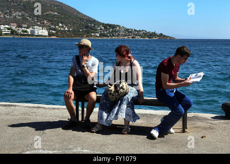 Attica Grecia PORTO RAFTI turisti seduta sul banco in porto Foto Stock