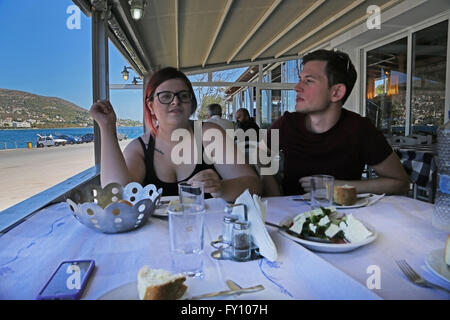 Attica Grecia PORTO RAFTI giovane mangiare pane in Taverna Foto Stock