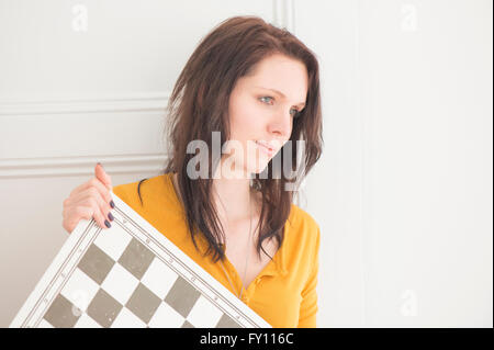 Donna seria azienda scacchiera in home interni. Concetto di strategia, le attività per il tempo libero e la contemplazione. Foto Stock