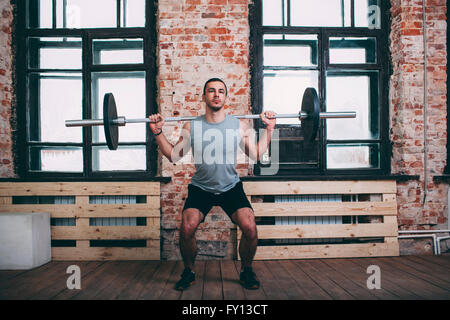 Uomo determinato il sollevamento barbell in palestra Foto Stock