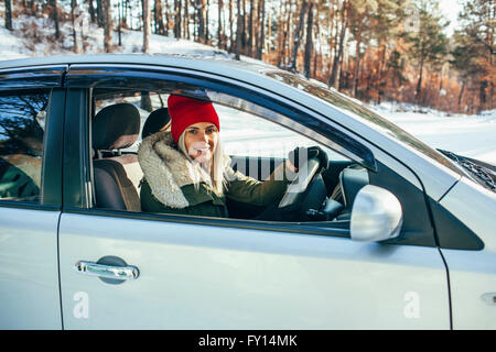 Ritratto di donna sorridente in un abbigliamento caldo auto pilotaggio Foto Stock