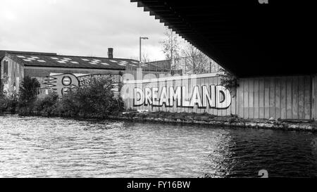 Graffiti accanto al canale con la parola 'Dreamland' su di esso. In bianco e nero. Foto Stock