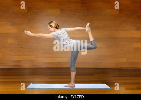 Donna fare yoga nel Signore della danza pone sul tappeto Foto Stock