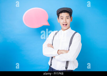 Ritratto di giovane uomo sorridente in stile retrò in posa con un palloncino di parlato Foto Stock