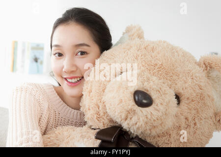 Ritratto di giovane donna sorridente con un grosso orso di peluche Foto Stock