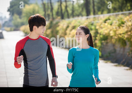 Giovane coppia sorridente esercitare presso il park faccia a faccia Foto Stock