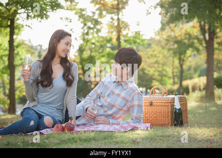 Giovane su un picnic al parco sia guardando ogni altro con un sorriso Foto Stock