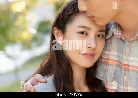 Donna con il suo fidanzato con lo sguardo in avanti con un sorriso Foto Stock