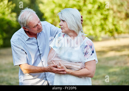 L uomo è consolante vecchia donna con braccio rotto in un loop Foto Stock