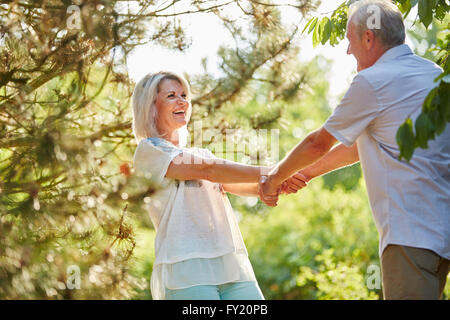 Coppia senior in amore tenendo le mani e flirtare Foto Stock