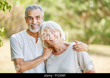 Coppia senior felicemente abbracciando in estate la natura Foto Stock