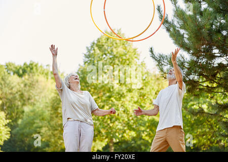 Happy seniors gettando hula hoops in aria e divertirsi Foto Stock