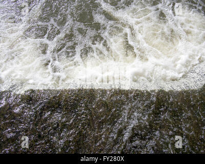 Acqua di fiume impetuoso su uno stramazzo. Foto Stock