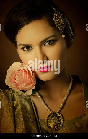 Bella donna asiatica con una rosa rosa Foto Stock