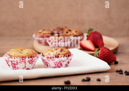 Fragole e cioccolato muffin di chip su sfondo di legno Foto Stock