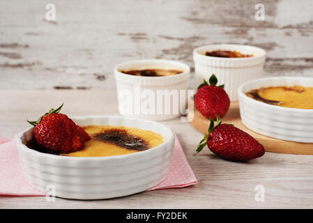 Creme brulee. Francese crema alla vaniglia dolce con zucchero caramellato sulla parte superiore. Crème brûlée. Legno rustico sfondo Foto Stock