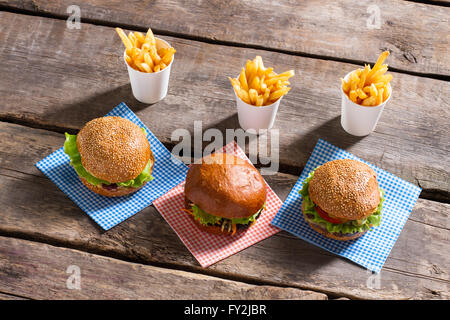 Cheeseburger su tovaglioli e patatine fritte. Foto Stock
