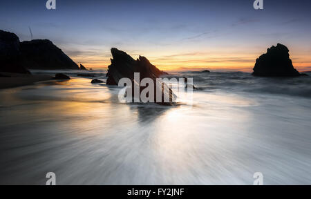 Il trascinamento dell'onda al tramonto. Foto Stock