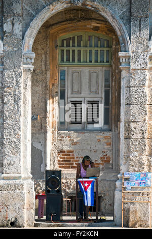 Ritratto verticale di un DJ melodie infront di un edificio fatiscente in Avana, Cuba. Foto Stock