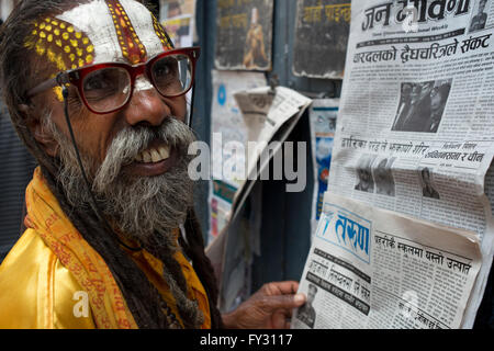 Indù nepalese uomo santo leggendo i giornali vicino a Basantapur, Kathmandu, Nepal Foto Stock