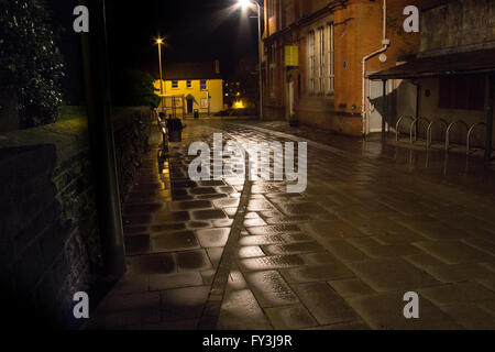 Un freddo, umido notte in Carmarthen ma c'è un sentimento atmosferica al marciapiede lungo la parte anteriore della chiesa di San Pietro. Foto Stock